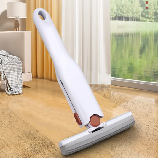 A white handheld mini portable mop on a wooden floor with a window and curtain in the background.