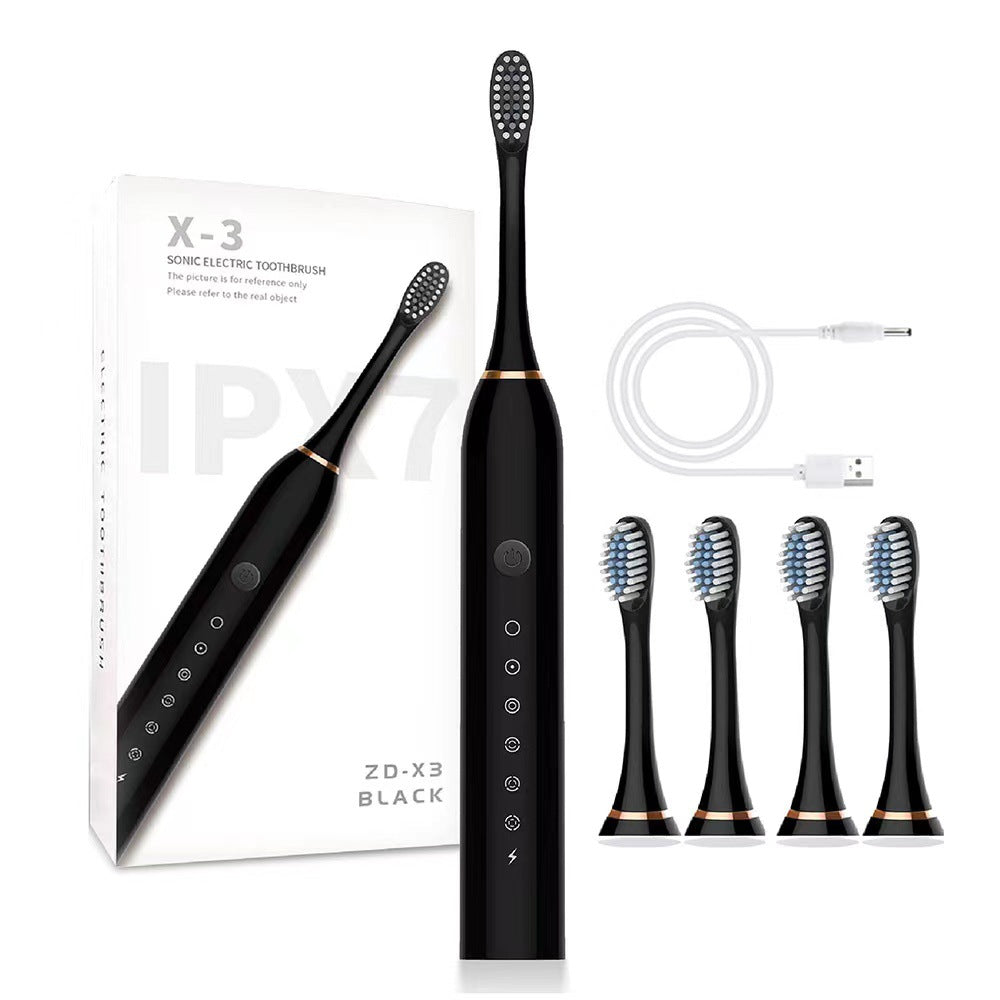 Black electric toothbrush with packaging, USB cable, and replacement heads on a white background