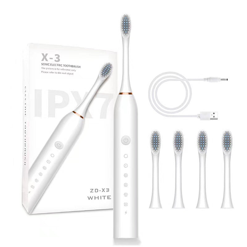 White electric toothbrush with packaging, USB cable, and multiple brush heads on a white background