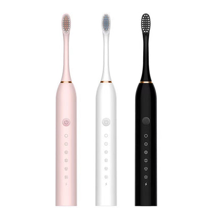 Three electric toothbrushes in pink, white, and black on a white background