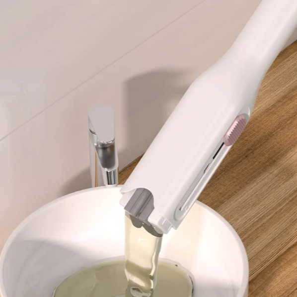 A white mini portable cleaning mop with a clear container on a wooden surface
